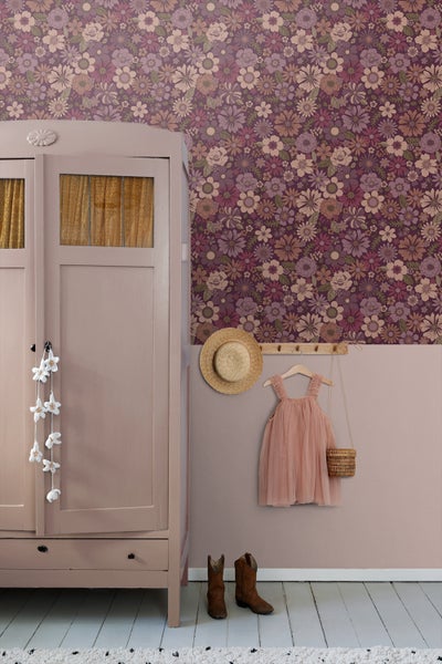 Raumansicht mit floraler Tapete, Kleiderschrank, Kinderkleidung und Accessoires