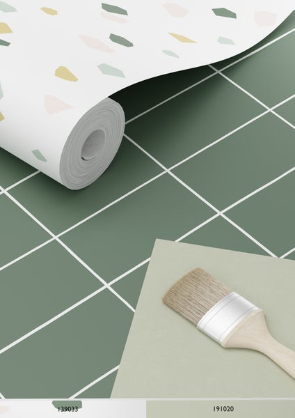 Tapetenrolle mit Muster und ein Pinsel auf einer Oberfläche mit quadratischem Muster