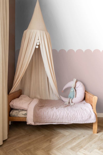 Kinderzimmer mit Holzbett, Baldachin und Mondkissen