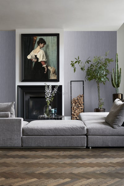 Wohnzimmer mit grauer modularen Couch, Kamin, Gemälde und Holzboden