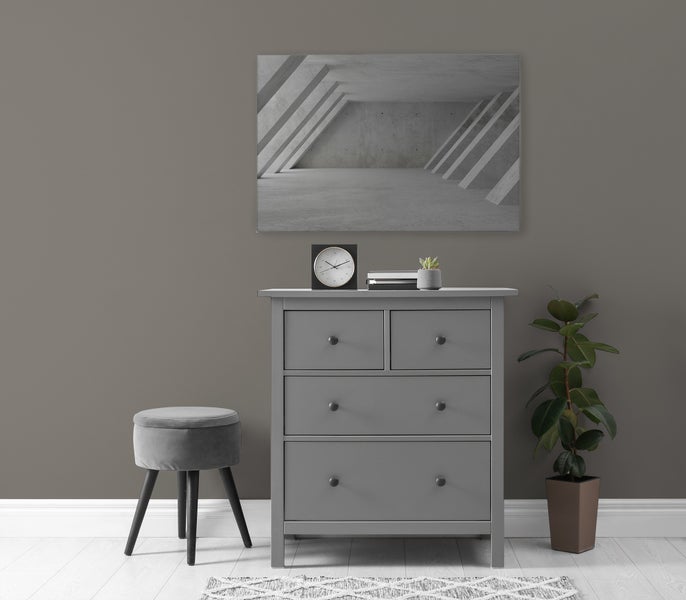 Eine moderne Kommode mit vier Schubladen, kombiniert mit einem runden Hocker und Wandbild in einem minimalistisch gestalteten Raum.