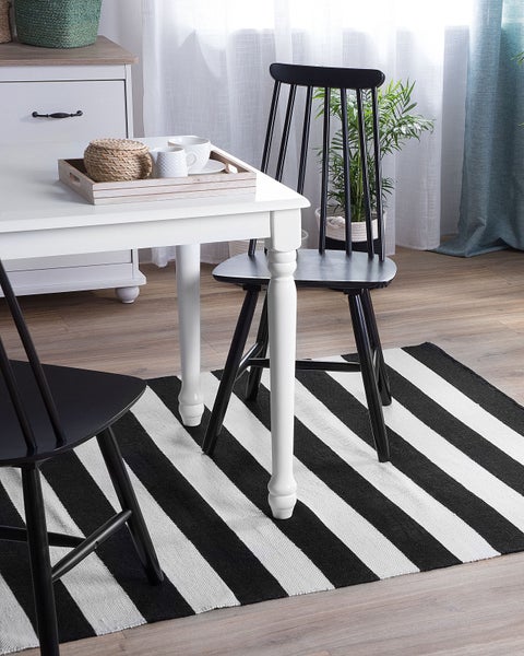 Rechteckiger Teppich mit vertikalen schwarz-weißen Streifen und gewebter Struktur.