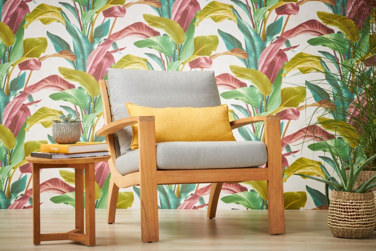 Schlafzimmer mit Dschungeltapete mit Pflanzenmotiven, Tisch und Zimmerpflanze