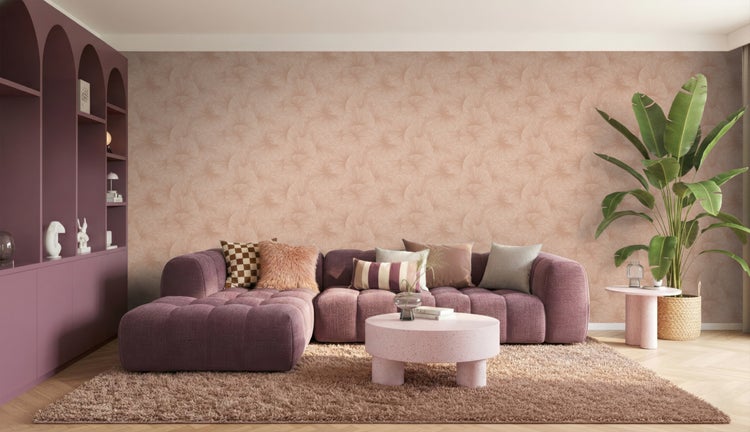 Modernes Wohnzimmer mit lila Polstersofa, gemusterter Tapete, rundem Couchtisch, großer Zimmerpflanze und flauschigem Teppich.