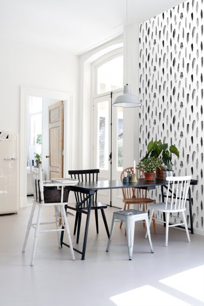 Esszimmer mit Esstisch, Stühlen und Tapete mit Federmuster