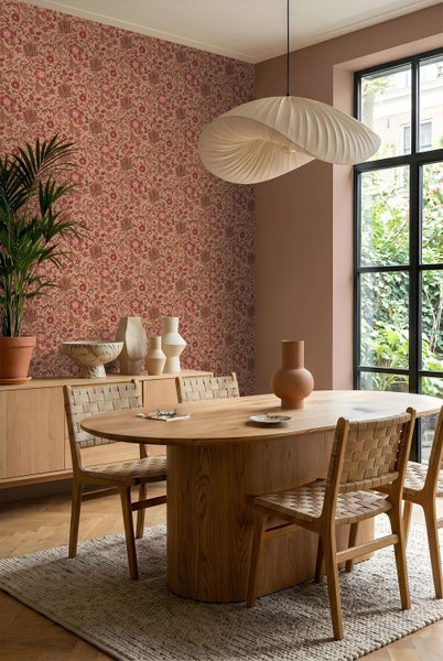Hell eingerichtetes Wohnzimmer mit modernem Sofa, runden Couchtischen aus Holz und einer dekorativen Tapetenbordüre mit Blattmuster.