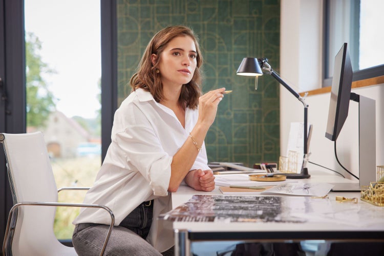 Interieuransicht mit grüner Tapete mit geometrischem Muster, Ledersofa und Bar