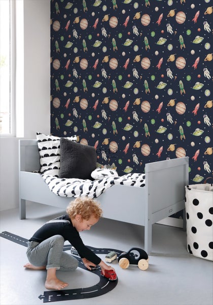 Kinderzimmer mit Weltraumtapete, Bett und spielendem Kind auf einem Spielzeugstraßenteppich