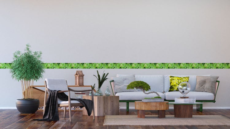Wohnzimmer mit grüner Bordüre mit Pflanzenmotiven an der Wand