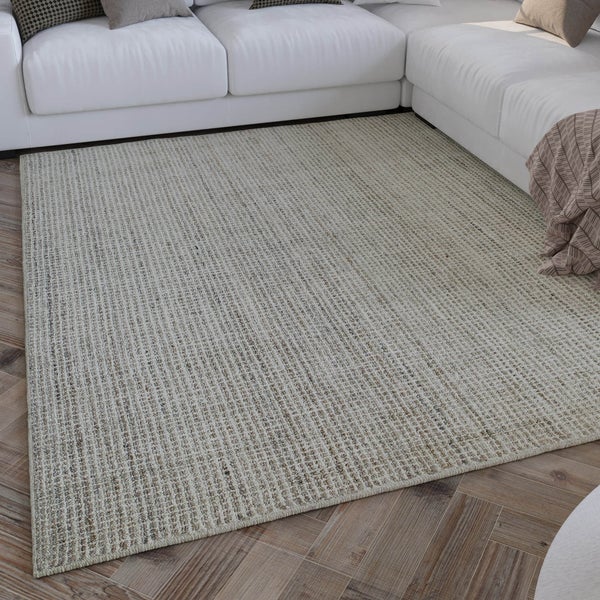 Gewebter Teppich in einem modernen, hellen Wohnzimmer vor einem weißen Ecksofa auf Holzfußboden.