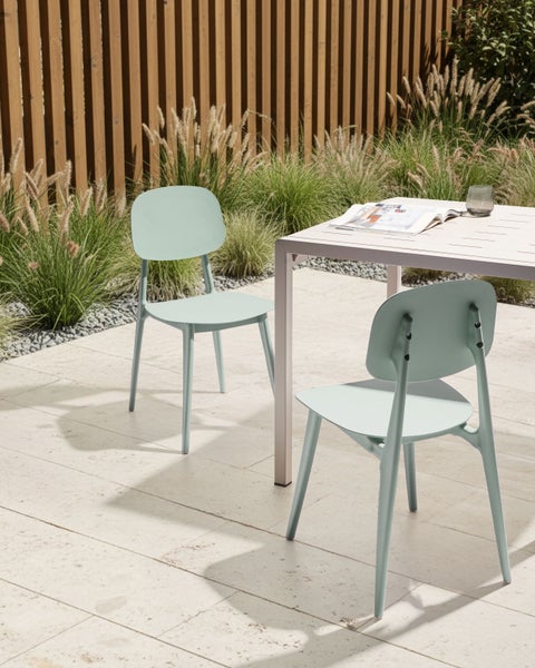 Szene mit zwei Gartenstühlen und einem Gartentisch auf einer Terrasse.