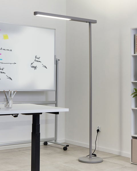 Stehleuchte im Büro mit Schreibtisch und Whiteboard