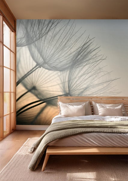 Schlafzimmer mit Fototapete mit Pusteblumenmotiv über einem Bett.