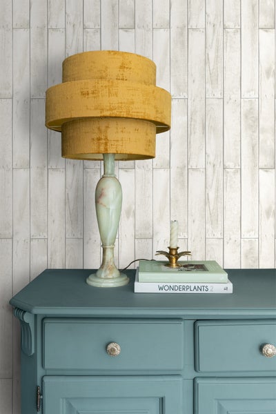 Dekorative Szene mit einer Tischlampe, Büchern, einer Kerze und einer Kommode