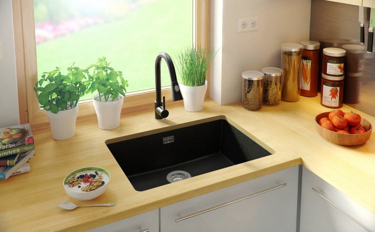 Küchenszene mit Spüle, Armatur und Lebensmitteln auf der Arbeitsfläche.