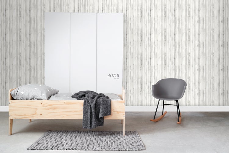 Zimmer mit Bett, Schrank, Schaukelstuhl und Teppich