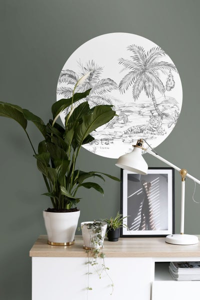 Zimmer mit Wandbild mit Tigern und Palme, Zimmerpflanzen, Tischlampe und Bilderahmen