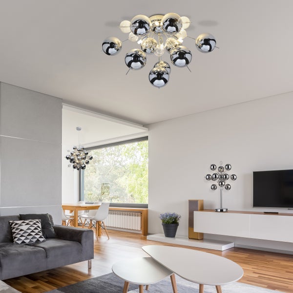 Wohnzimmer mit moderner Einrichtung, inklusive Deckenleuchte mit kugelförmigen Lampenschirmen