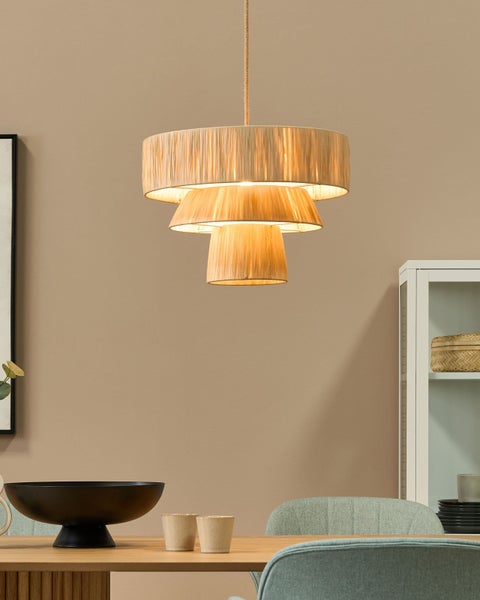 Mehrstufige Hängeleuchte aus Textil über einem Esstisch in einem hellen Raum.