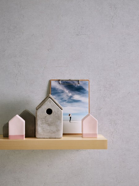 Dekorative Szene mit Holzregal, Häusern aus Beton und Bild auf Klemmbrett.