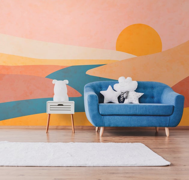 Kinderzimmer mit blauem Sofa, Bärlampe auf Nachttisch und gemusterter Tapete