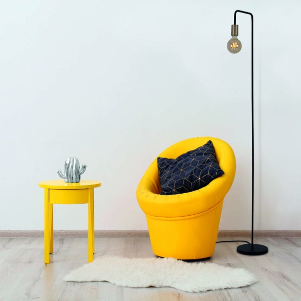 Dekoratives Wohnambiente mit Stehlampe, Pflanzgefäßen und Dinosaurierfigur