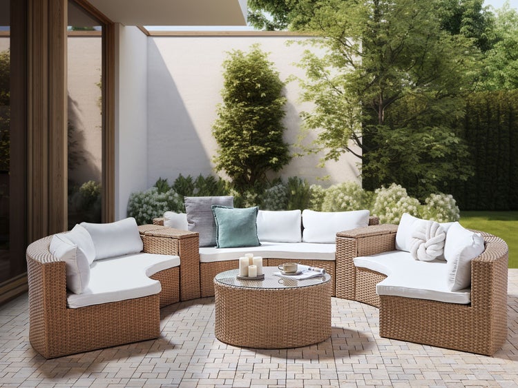 Gartenmöbelset aus Rattan mit Sofa, Sesseln und Tisch auf einer Terrasse