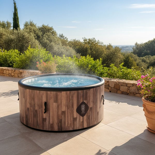 Aufblasbarer runder Whirlpool in Holzoptik auf einer hellen Terrasse im Außenbereich mit Gartenblick.