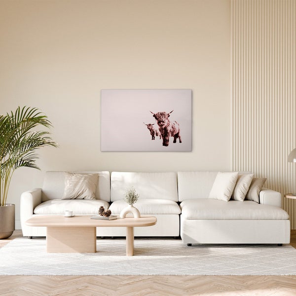 Wohnzimmer mit Sofa, Couchtisch und einem Wandbild, das zwei Hochlandrinder zeigt.