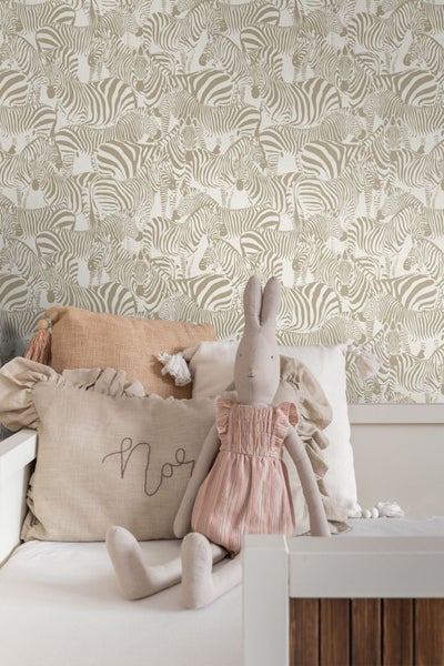 Organisiertes Kinderzimmer mit einer Zebra-Mustertapete, einem Holzregal mit Holzspielzeug und Kuschelbär sowie einer Wandgarderobe.