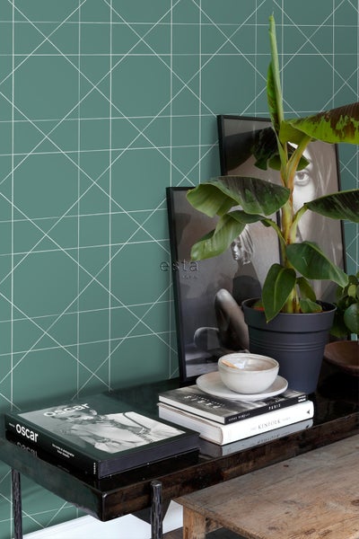 Dekoratives Zimmer mit geometrischer Tapete, Topfpflanze und Bilderrahmen