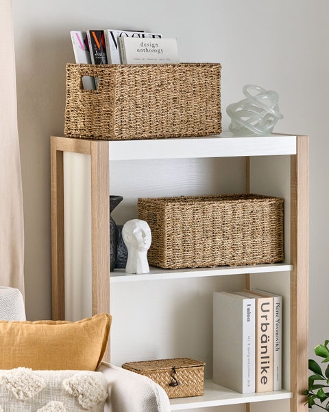 Regal mit zwei geflochtenen Aufbewahrungskörben, Büchern und dekorativen Objekten