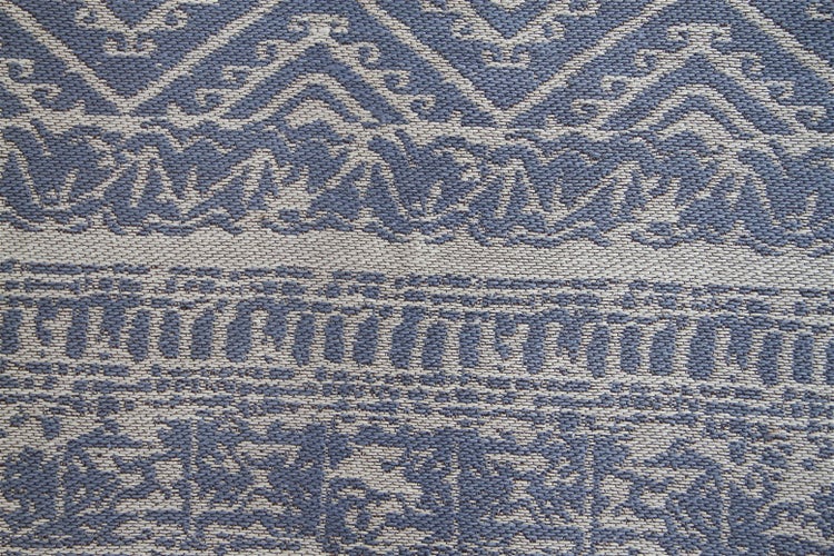 Detailansicht eines gewebten Teppichs mit ornamentalen und geometrischen Mustern.