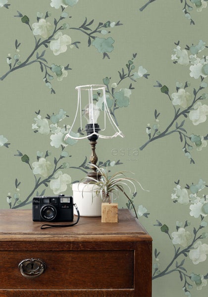 Zimmeransicht mit Blümchentapete, Tisch, Lampe und Kamera