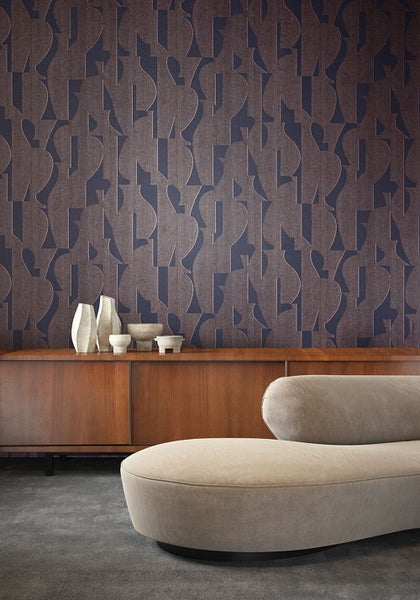 Wohnraum mit Sofa, Kommode und gemusterter Tapete