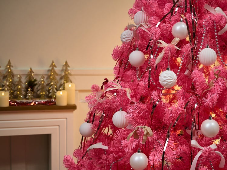 Dekorierter rosa Weihnachtsbaum mit Kugeln und Schleifen.