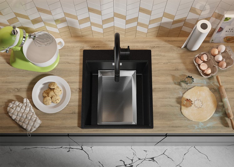 Küchenszene mit Spüle, Armatur, Küchenmaschine, Kochbuch und Backutensilien auf einer Arbeitsplatte