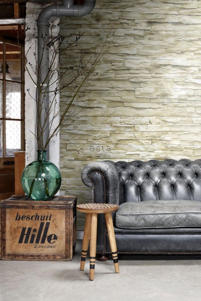 Dekoratives Wohnzimmer mit Couch, Hocker, Holzkiste und Glasvase