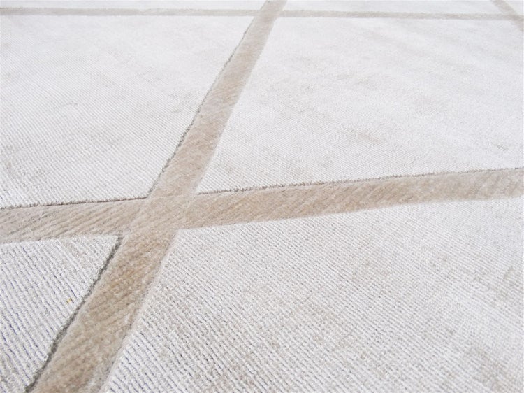 Nahaufnahme eines Teppichs mit geometrischem Rautenmuster und weicher Florstruktur.