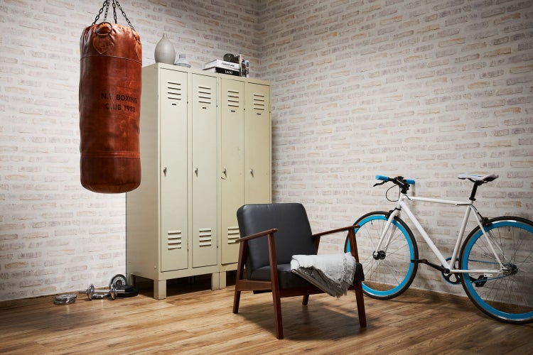 Wohnraum mit Boxsack, Spind, Sessel und Fahrrad