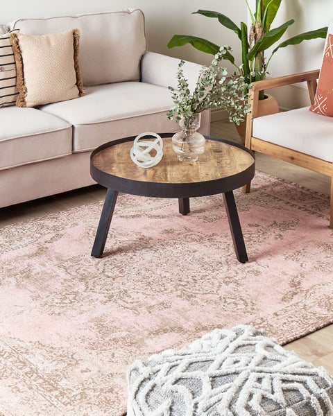 Wohnzimmer mit Sofa, Sessel, Couchtisch und gemustertem Teppich