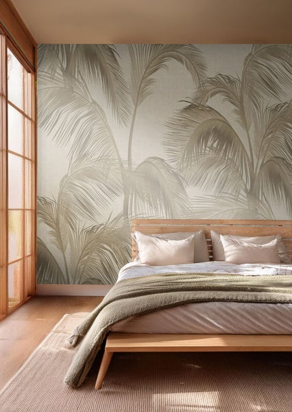 Schlafzimmer mit Fototapete mit Palmenmotiv, Bett und Teppich.