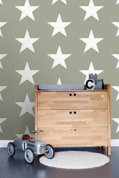 Kinderzimmer mit Holzkommode, Spielzeugauto und Sternentapete