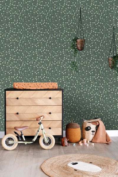 Kinderzimmer mit Kommode, Laufrad, Spielzeug und Blumentapete