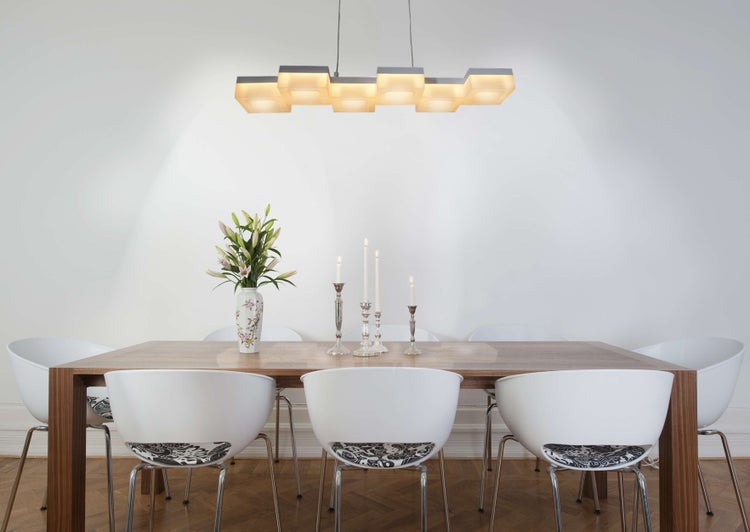 Helles Esszimmer mit Holztisch, weißen Stühlen und moderner Pendelleuchte