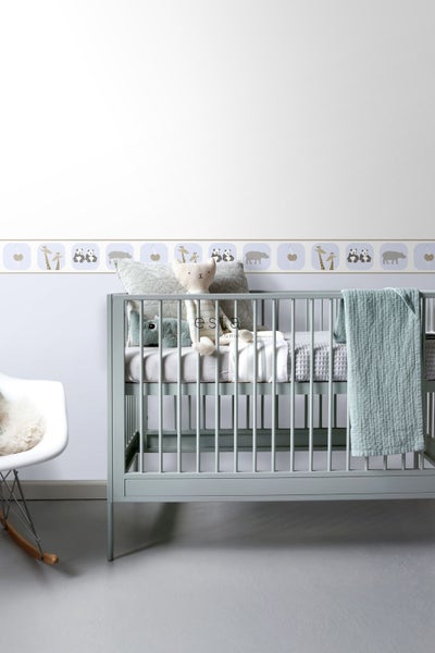 Kinderzimmer mit Gitterbett, Kuscheltieren und Bordüre mit Tiermotiven