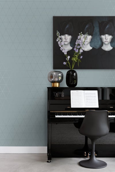 Wohnzimmer mit geometrischer Tapete, Klavier, Lampe, Vase und Gemälde