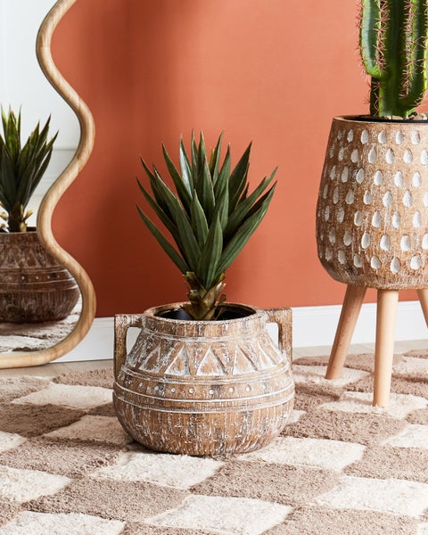 Dekorative Pflanzgefäße und ein Spiegel auf einem gemusterten Teppich