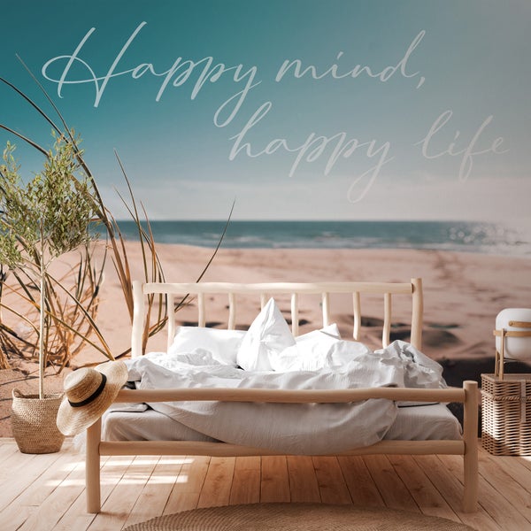 Schlafzimmer mit Fototapete mit Strandmotiv und dem Schriftzug Happy Mind, Happy Life