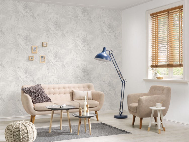 Gemütliches Wohnzimmer mit gestreiftem Sofa, Sessel und Fenstern mit Sprossen